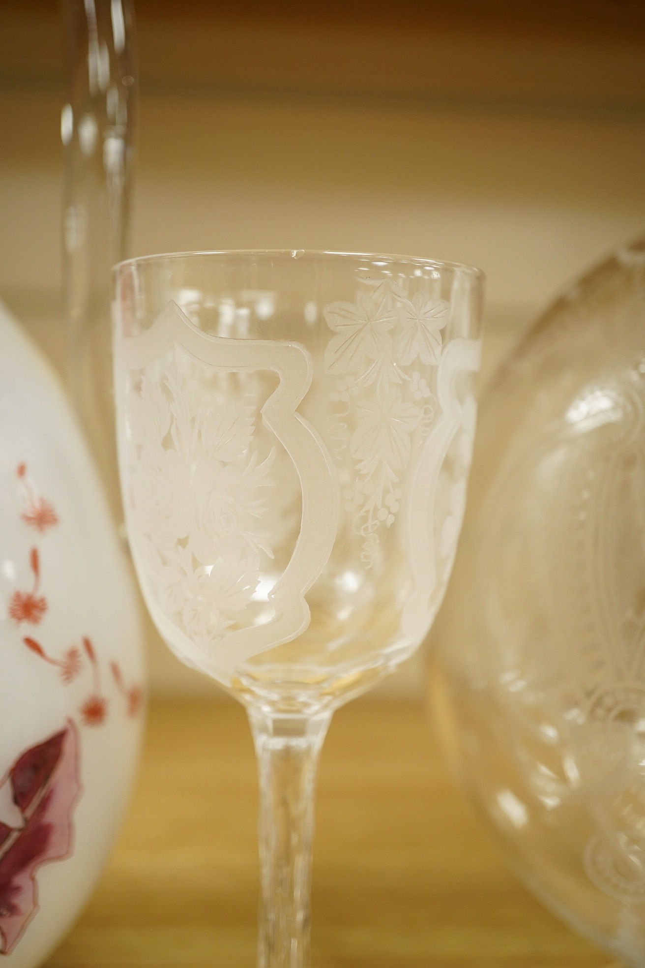 A Continental Art Nouveau glass carafe enamelled with flowers, an English wine glass engraved with the symbols of the Union, a Victorian engraved claret jug and a toddy lifter. Condition - carafe has some occasional scra